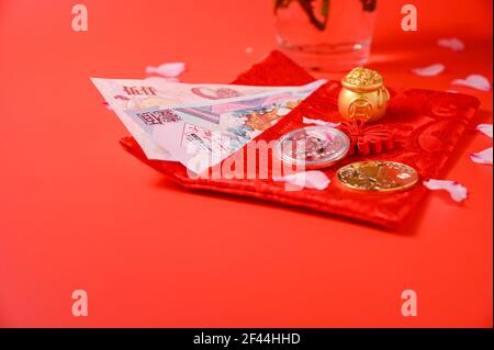 Il nuovo anno cinese 2021 è l'anno del bue, caratteri cinesi . Ornamento cinese di nuovo anno. Lingotto d'oro e abaco d'oro. Petalo di mandorle e monete in fiore su sfondo rosso. Spazio di copia Foto Stock