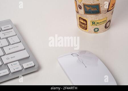 Vista della tastiera e del mouse di un computer moderno con una tazza di caffè. Foto Stock