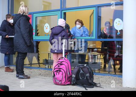 Halberstadt, Germania. 19 marzo 2021. Gli alunni si trovano con i genitori di fronte al centro di test della scuola elementare Anne-Frank di Halberstadt e aspettano un test rapido Corona gratuito. A Halberstadt, sono stati avviati test rapidi gratuiti in 5 scuole. Un totale di 30 studenti si sono volontari per essere testati. Da lunedì in poi, in tutte le scuole della Sassonia-Anhalt saranno effettuati test rapidi. Credit: Matrhias Bein/dpa-Zentralbild/dpa/Alamy Live News