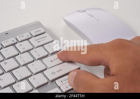 Tasto DI pressione della tastiera con la mano maschile ENTER. Concetto online. Foto Stock