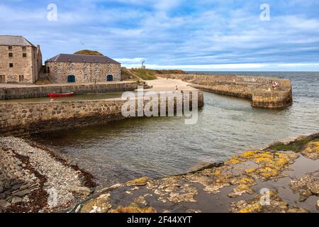 PORTSOY OLD HARBOUR MORAY FIRTH ABERDEENSHIRE SCOZIA LE VECCHIE CASE UNA SPIAGGIA DI SABBIA E UNA BARCA ROSSA Foto Stock