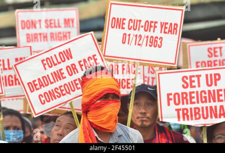 Dimapur, India. 19 marzo 2021. Un manifestante si trova di fronte a persone che tengono un cartello durante un raduno pubblico contro il governo per attuare il Registro degli abitanti indigeni di Nagaland (RIIN) e il permesso di linea interna (ILP) prima del 31 marzo 2021 a Dimapur, India, stato nord-orientale di Nagaland. Nagaland, il 16° stato dell'India, è uno stato indigeno tribale. Credit: Caisii Mao/Alamy Live News Foto Stock