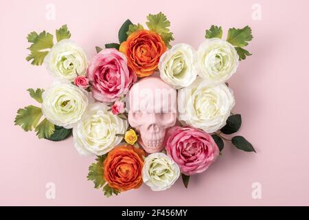 Layout creativo di Halloween fatto di cranio rosa con fiori su sfondo rosa. Concetto di vacanza minimo. Foto Stock