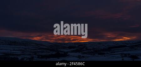 Tramonto spettacolare su colline e montagne innevate (Weardale, North Pennines, County Durham, Regno Unito) Foto Stock