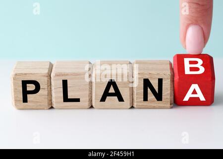 Femmina finger flipping cubo di legno con piano a e b segnali Foto Stock