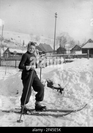 Ragazza con sci di fronte alla casa del fotografo Foto Stock