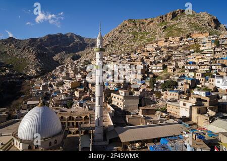 Akre, Iraq. 18 Marzo 2021. Vista delle case costruite sulla montagna della città vecchia di Akre. La città di Akre nel governatorato di Duhok si sta preparando a celebrare Nowruz (il Capodanno persiano o il Capodanno curdo) da bandiere appese sulle montagne. Il nuovo anno persiano o il nuovo anno curdo è una vecchia tradizione zoroastriana celebrata dagli iraniani e dai curdi il 20 marzo di ogni anno e coincide con l'equinozio vernale. (Foto di Ismael Adnan/SOPA Images/Sipa USA) Credit: Sipa USA/Alamy Live News Foto Stock