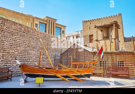 Esplorate lo stile di vita storico nella corte del Forte al Fahidi, qui si possono trovare le tradizionali barche in legno e la casa estiva arish, fatta di crusca di palme Foto Stock