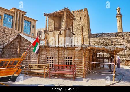 Casa estiva tradizionale arish, fatta di materiali di palma con torre del vento e portico ombreggiato alla corte del Forte al Fahidi, Dubai, Emirati Arabi Uniti Foto Stock