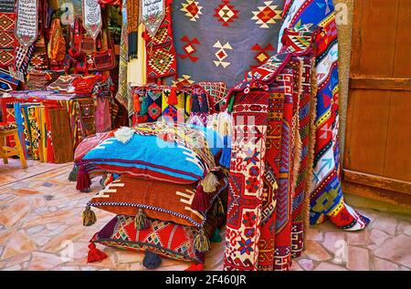 I tappeti colorati, i tappeti, i federe dei cuscini e gli arazzi nello stallo di al Souk al Kabir (mercato Vecchio) a Dubai, Emirati Arabi Uniti Foto Stock
