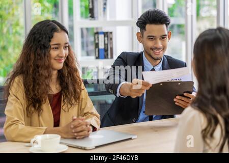 Senior Asian Manager che spiega o risponde sulla descrizione del lavoro e. Benefici per giovane donna asiatica laureata con movimento positivo dentro Sala meeting, autobus Foto Stock