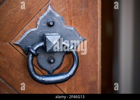 Maniglia della porta knocker fuoco selettivo su marrone vecchia chiesa di legno porta d'ingresso con copyspace. Foto Stock