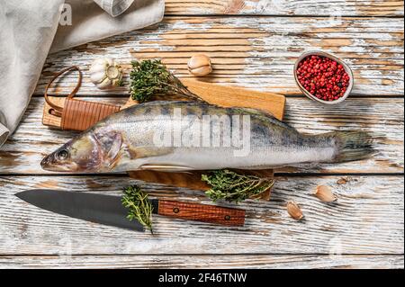 Pesce persico crudo, pesce pikeperch su un tagliere. Pesce fresco. Sfondo bianco. Vista dall'alto Foto Stock