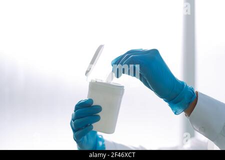 immagine di un medico che preleva un panno umido da un contenitore . Foto Stock