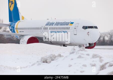 Ucraina, Kiev - 12 febbraio 2021: Aerei in inverno. Velivolo. C'è molta neve all'aeroporto. Cattive condizioni meteorologiche e visibilità. Blocchi di neve. Nevicate. C'è molta neve all'aeroporto. Foto Stock