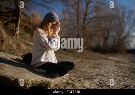 Pratica della meditazione e dell'interazione con la natura. Ragazza vicino al fiume Foto Stock