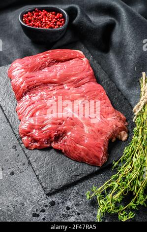 Bistecca cruda, carne marmorizzata. Sfondo nero. Vista dall'alto. Spazio di copia Foto Stock