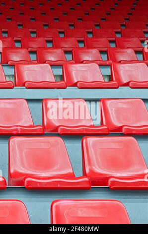 Sedili in plastica rossa numerati per lo stadio - vista verticale Foto Stock