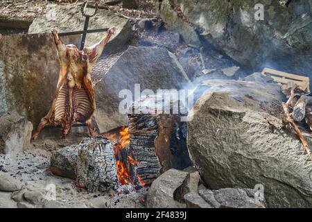 Barbecue rustico di agnello sul fuoco aperto in Patagonia, Argentina, Sud America. L'asado è un traditon di Gaucho con cucina a fiamma libera Foto Stock