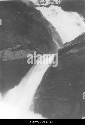 A Merok (Norvegia). Su grandi rocce ripide in discesa cascata, sul corso superiore si erge un solo gentleman Foto Stock