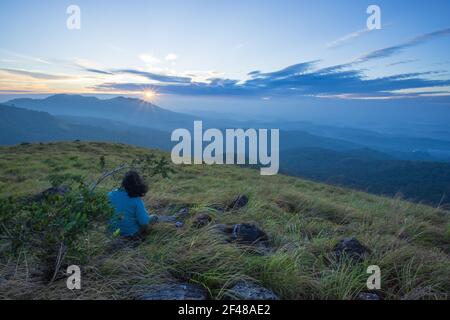 Una signora che gode della magnifica vista da una collina a Wayanad durante la mattina presto (immagine presa a Wayanad, Kerala) Foto Stock