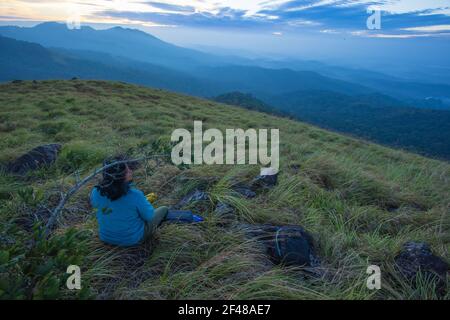 Una signora che gode della magnifica vista da una collina a Wayanad durante la mattina presto (immagine presa a Wayanad, Kerala) Foto Stock