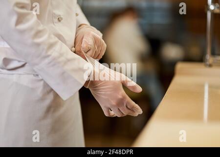Chef sempre pronto per il lavoro e indossare i guanti Foto Stock