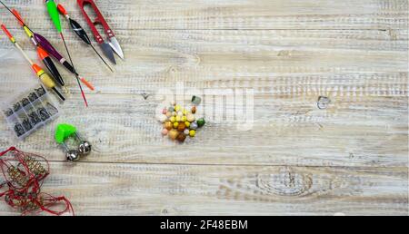 tackles pesca per pescatori - nuotatori, piombi e attrezzi su sfondo di legno. Messa a fuoco selettiva Foto Stock