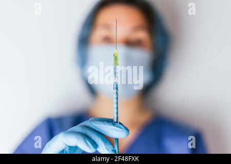 Le mani di un medico con una siringa in mano. Foto Stock
