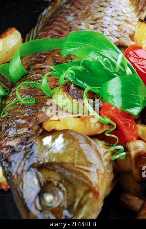 Pesce al forno con verdure, funghi e limone. Foto Stock
