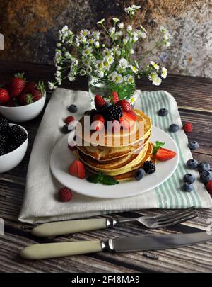 Pancake su un piatto bianco con posate. Colazione in stile provenzale. Vista verticale.