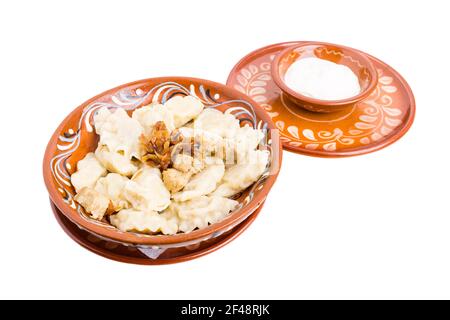 Gnocchi russi pelmeni ripieni di carne e patate. Servito con panna acida. Isolato su sfondo bianco. Foto Stock