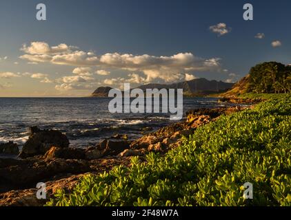 Tramonto spettacolare a Paradise Cove, onde dell'Oceano Pacifico che si infrangono su rocce vulcaniche lungo la costa idilliaca, Kapolei, Oahu, Hawaii, USA Foto Stock