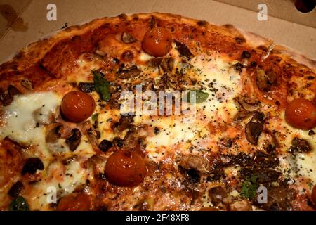 Pizza con funghi e pomodori ciliegini Foto Stock