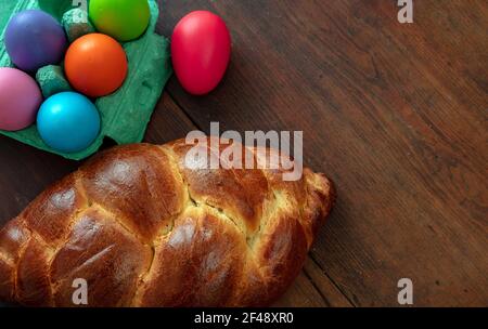 Modello biglietto di auguri di Pasqua. Pane dolce di pasqua ortodosso e uova colorate, pane tsoureki cozonac su sfondo tavola di legno, reli tradizionali festosi Foto Stock