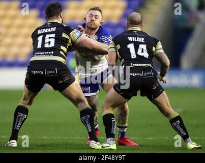 Josh Charnley di Warrington Wolves (al centro) affrontato da Alex Gerrard di Leigh Centurions (a sinistra) e Matthew Wildie durante l'incontro di testimonianza di Chris Hill allo stadio Halliwell Jones di Warrington. Data immagine: Venerdì 19 marzo 2021. Foto Stock