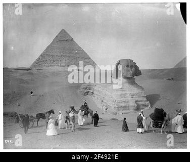 Giza (Egitto): Carovana di cammello davanti alla Sfinge di Giza. Locali con cammelli. Turisti con un cavallo di fronte alla Sfinge di Giza Foto Stock