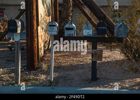 Una fila di caselle di posta di fronte a un paesaggio desertico Foto Stock