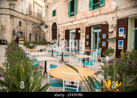 Tavoli da ristorante vuoti in una piccola città d'Italia Foto Stock