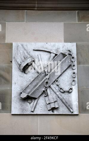 Oggetti relativi alla miniera di piombo su una placca sul Facciata della Sala dei Moot di Wirksworth Foto Stock