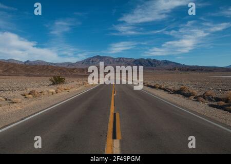Ampio scatto della strada nel deserto, con una montagna dritta Foto Stock