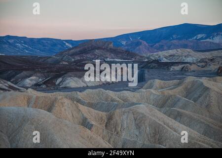 Zabriskie Point al tramonto, con una strada vuota in lontananza Foto Stock
