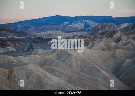 Zabriskie Point al tramonto, con una strada vuota in lontananza Foto Stock