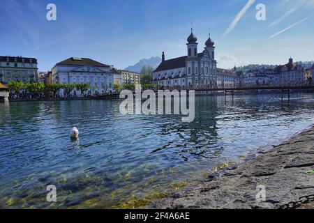 Vista panoramica della chiesa gesuita di Lucerna sul lato del fiume Reuss nel centro storico di Lucerna con riflessione in acqua, in una giornata estiva con nuvole di cielo blu Foto Stock