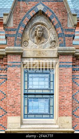 La Memorial Hall dell'Università di Harvard raffigura grandi oratori (Burke qui) alla sua estremità orientale (Sanders Theatre), su Quincy Street a Cambridge, Mass. Foto Stock