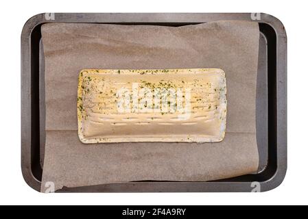 Pasta sfoglia surgelata con salmone adagiato su una teglia da forno su carta da forno, isolata su sfondo bianco con un percorso di ritaglio, vista dall'alto. Foto Stock