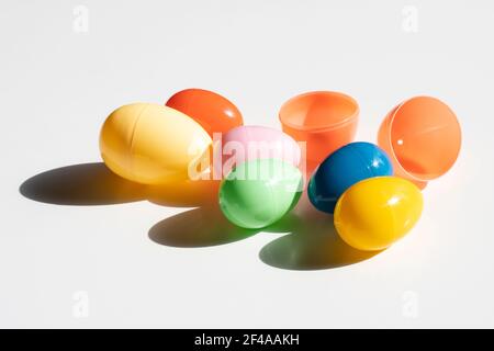 Colorate uova di Pasqua in plastica al sole isolate su uno sfondo bianco. Foto Stock