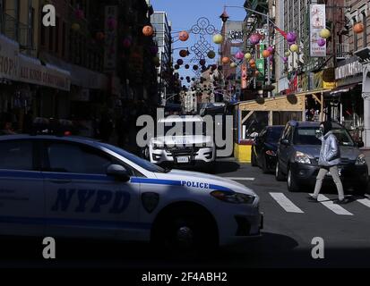 New York, Stati Uniti. 19 marzo 2021. Due veicoli della polizia della NYPD si dirigono in direzioni diverse a Chinatown sotto e intorno alle decorazioni di strada cinesi a New York City venerdì 19 marzo 2021. Il presidente Biden venerdì ha esortato il Congresso ad approvare la legislazione sul crimine di odio per affrontare l'aumento della discriminazione e della violenza contro gli americani asiatici durante la pandemia della COVID-19. Foto di John Angelillo/UPI Credit: UPI/Alamy Live News Foto Stock