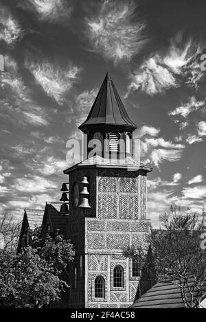 Bianco e nero, edificio con campane, campanile contro il cielo con bianche nuvole soffici. Foto Stock