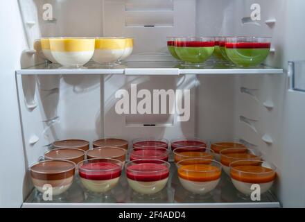 Varietà di dolci gustosi dolci in vasetti di plastica nella frittura, fuoco selettivo. Deliziosa panna cotta con lamponi. Foto Stock